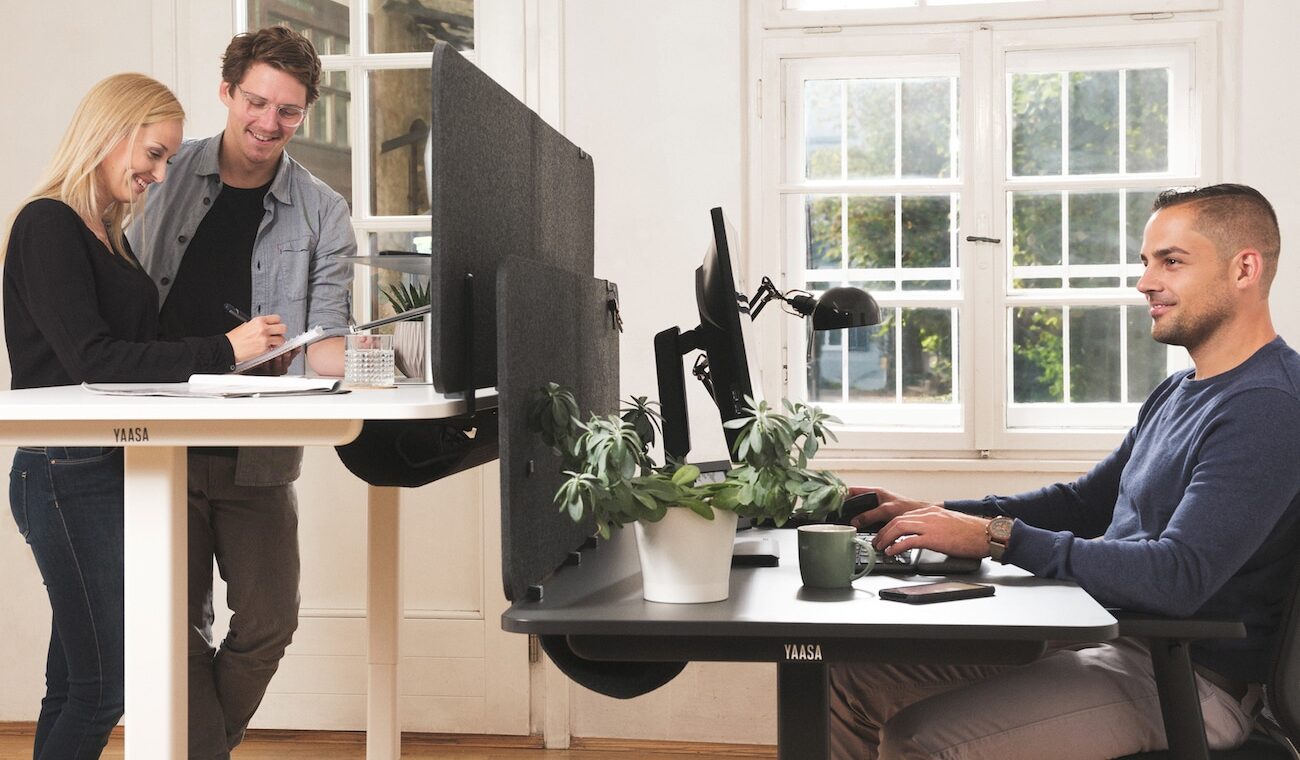 Mann und Frau arbeiten im Stehen am Schreibtisch in einem Büro.